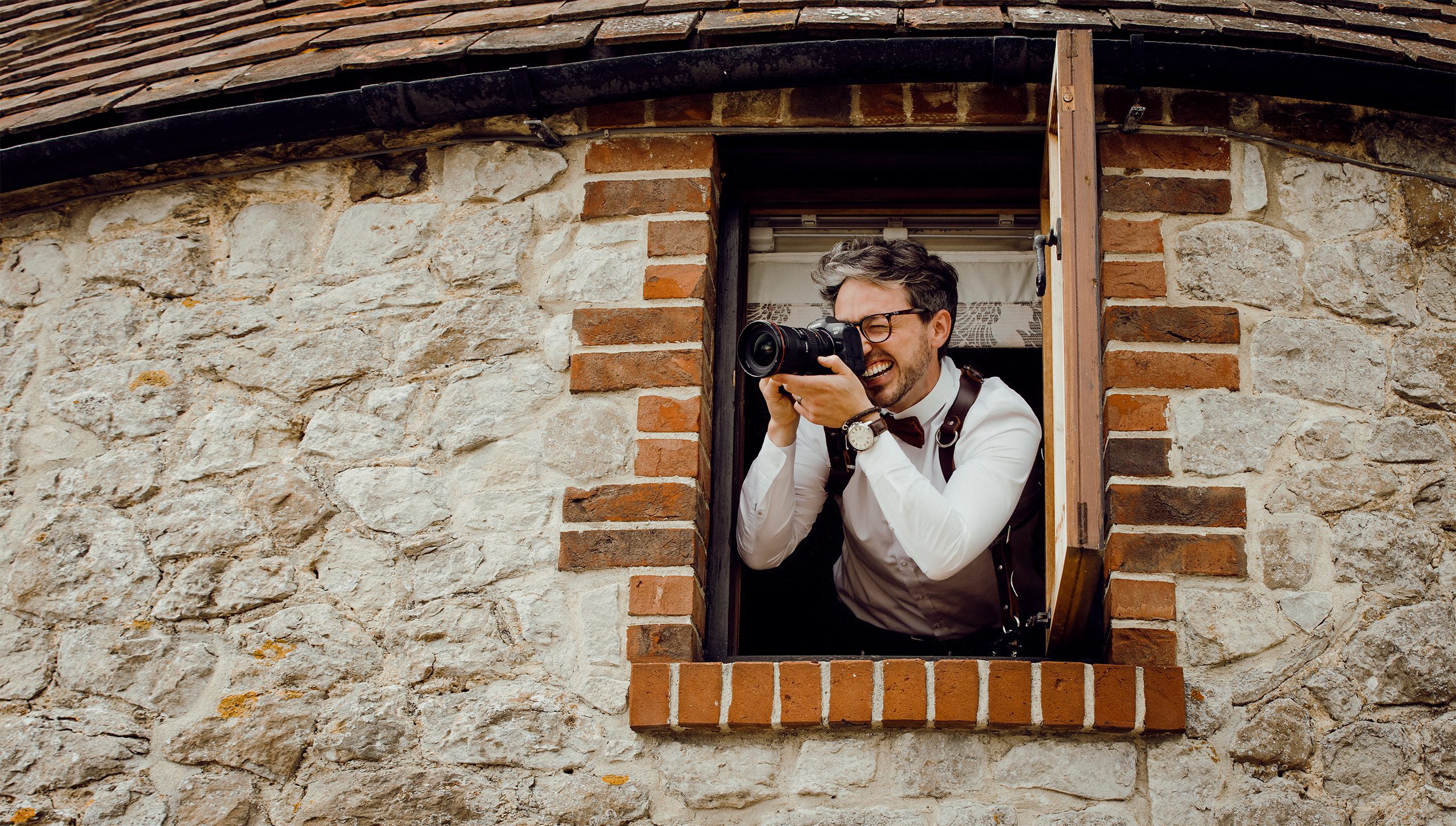 Photographer hanging from window